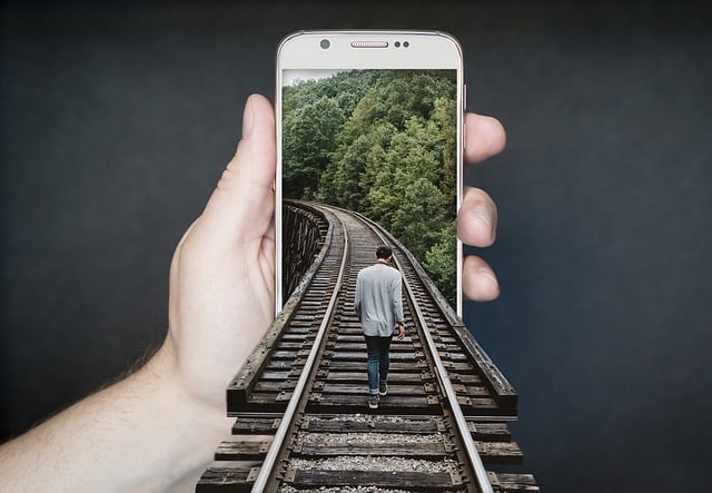 image montrant un homme marchant sur un rail de train dans un téléphone