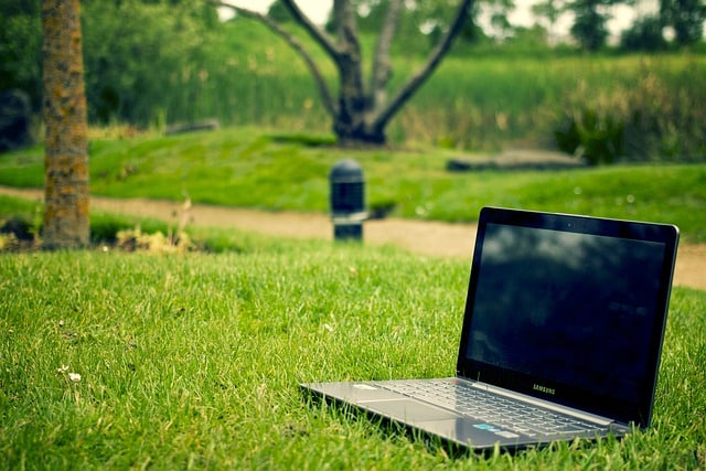 image d'un ordinateur portable poser sur de l'herbe