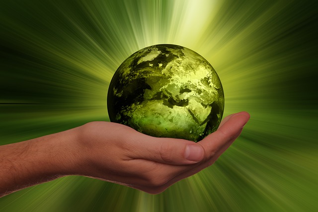 photo d'une main tenant la terre avec une halo vert pour symboliser l'eco conception